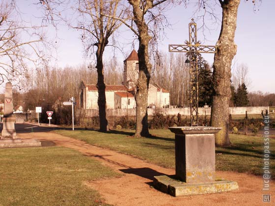 Une grande place ombrag�e, avec le monument aux mort et une croix assez r�cente.